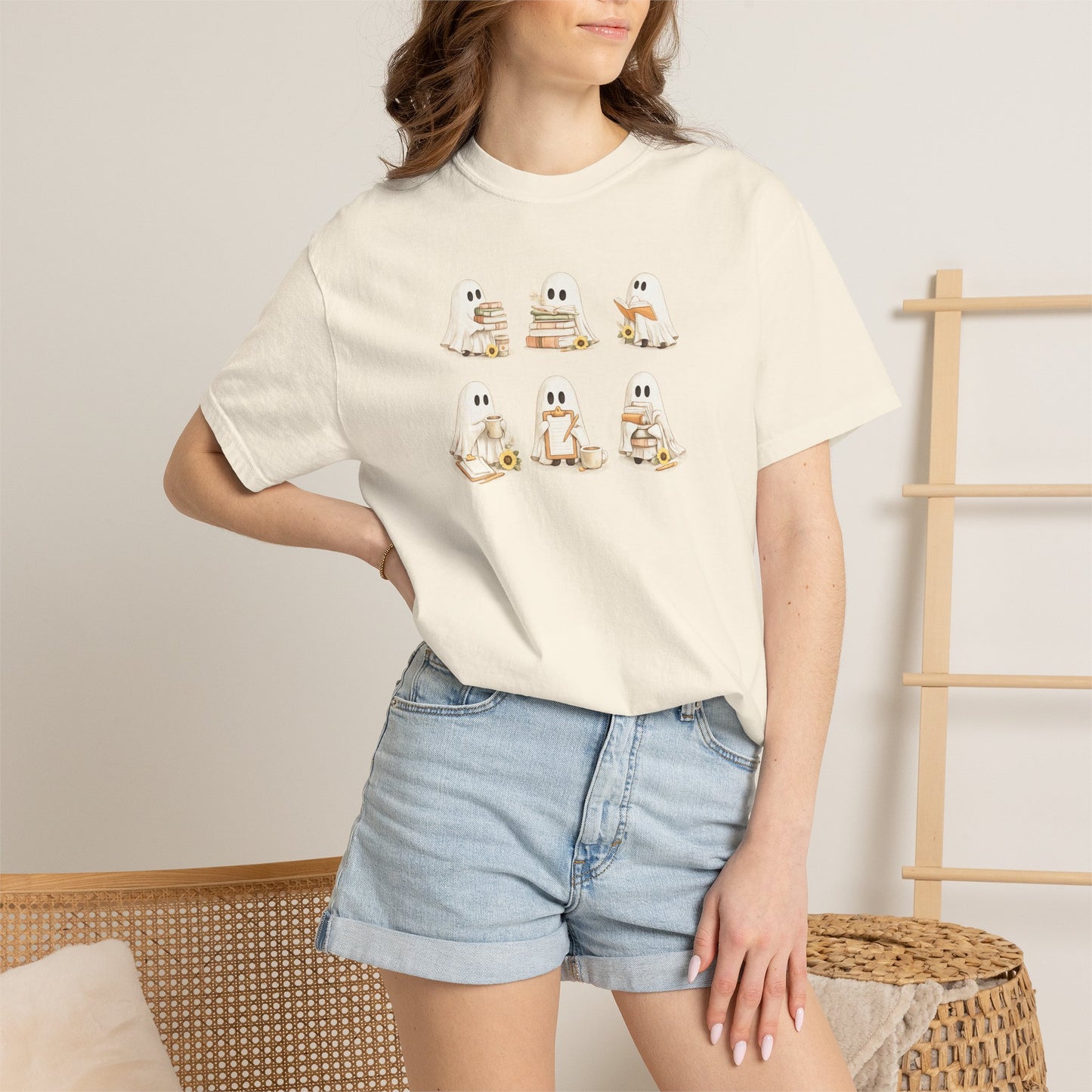 Woman wearing cream Comfort Colors Ghost Teacher Shirt with hand-illustrated ghosts holding books design - The Teechers Thread