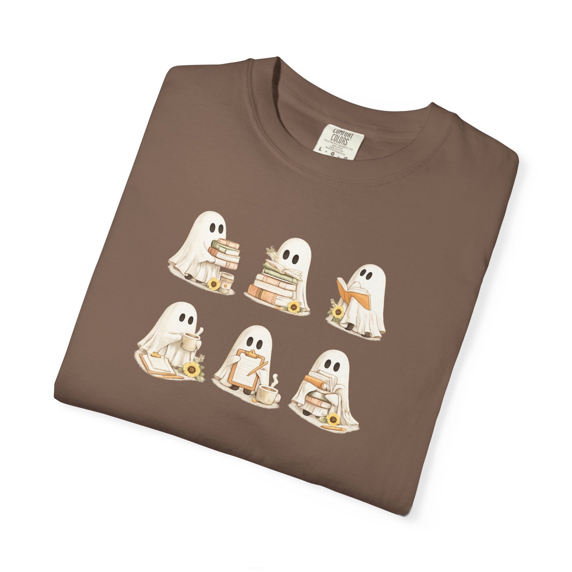 Brown Comfort Colors t-shirt folded flat lay with six hand-illustrated ghosts holding books design - Ghost Teacher Shirt by The Teechers Thread
