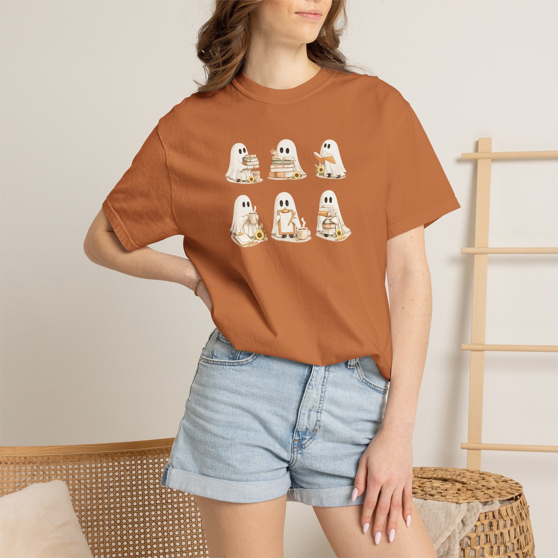 Woman wearing rust orange Comfort Colors Ghost Teacher Shirt with hand-illustrated ghosts holding books design - The Teechers Thread