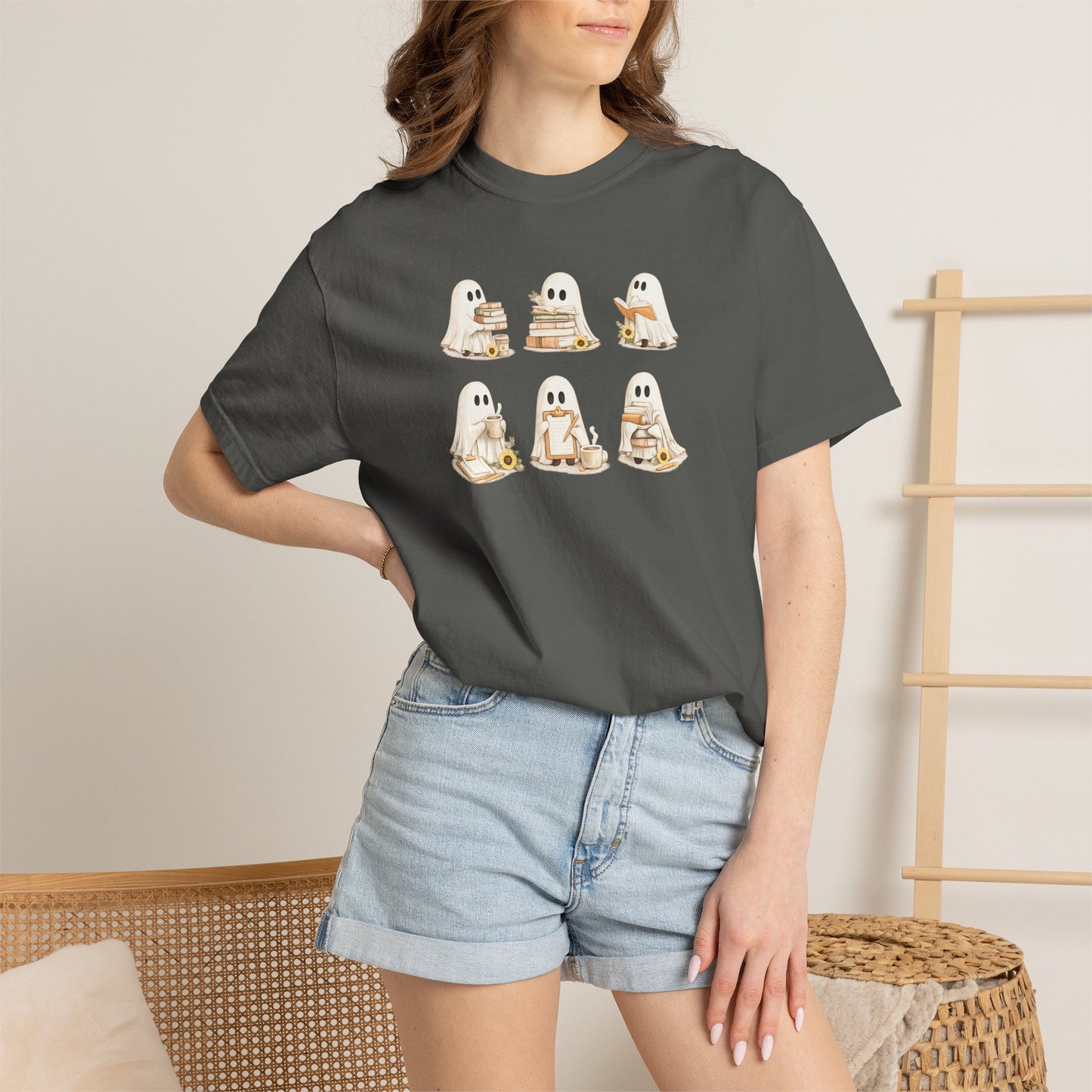 Woman wearing charcoal grey Comfort Colors Ghost Teacher Shirt with hand-illustrated ghosts holding books design - The Teechers Thread