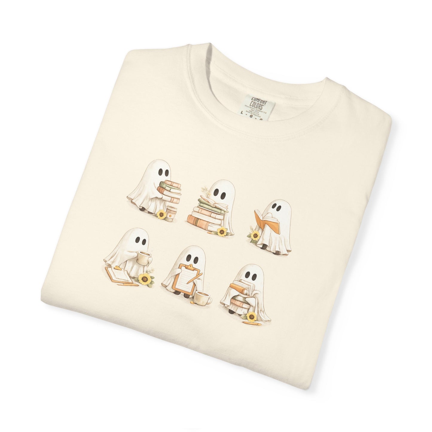 Cream Comfort Colors t-shirt folded flat lay with six hand-illustrated ghosts holding books design - Ghost Teacher Shirt by The Teechers Thread