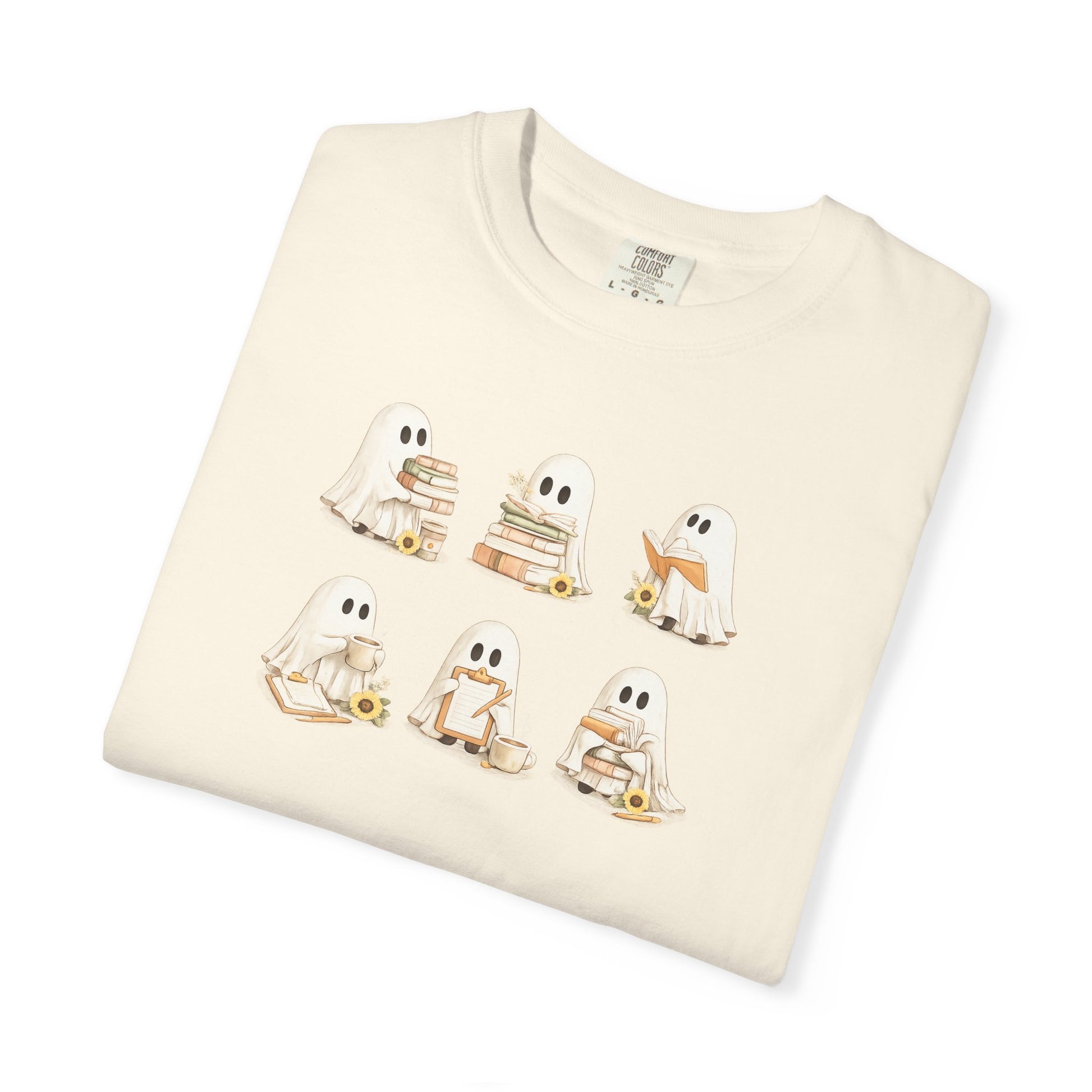 Cream Comfort Colors t-shirt folded flat lay with six hand-illustrated ghosts holding books design - Ghost Teacher Shirt by The Teechers Thread