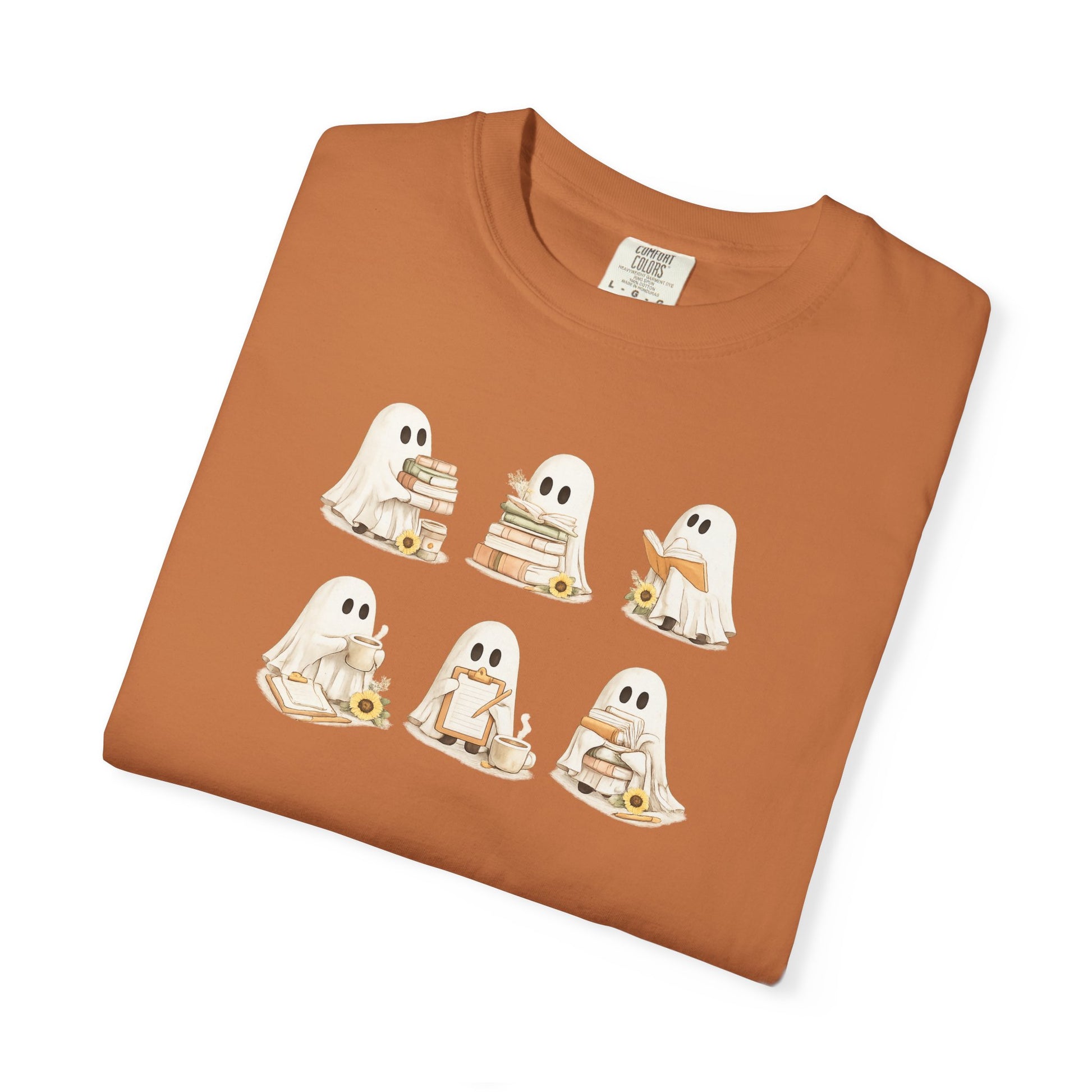Rust orange Comfort Colors t-shirt folded flat lay with six hand-illustrated ghosts holding books design - Ghost Teacher Shirt by The Teechers Thread